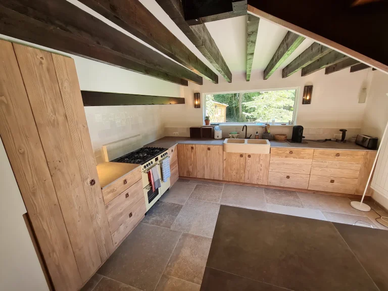 Cuisine sur mesure en bois massif sous poutres apparentes, sol en pierre – T2AE, Louviers