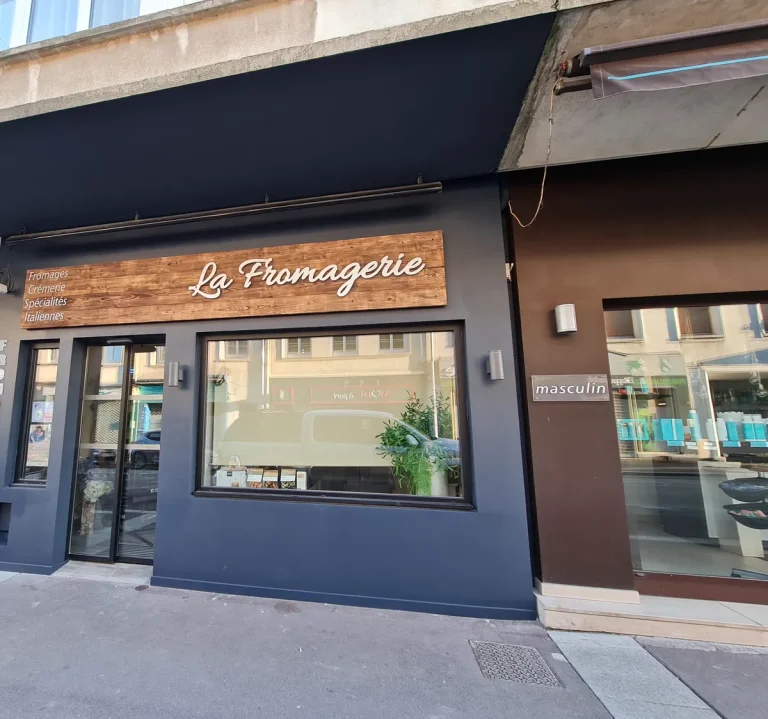 Façade de fromagerie rénovée : devanture peinte en bleu nuit et enseigne en bois – T2AE, Louviers
